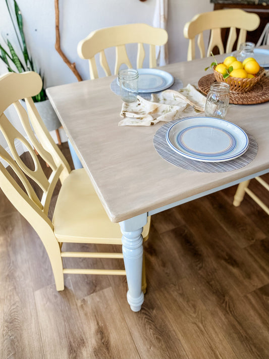 Light wood stained dining table top with light yellow chairs