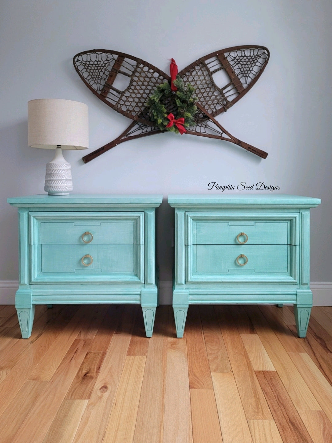 Teal blue painted matching nightstands with white lamp and snowshoe winter wall decor