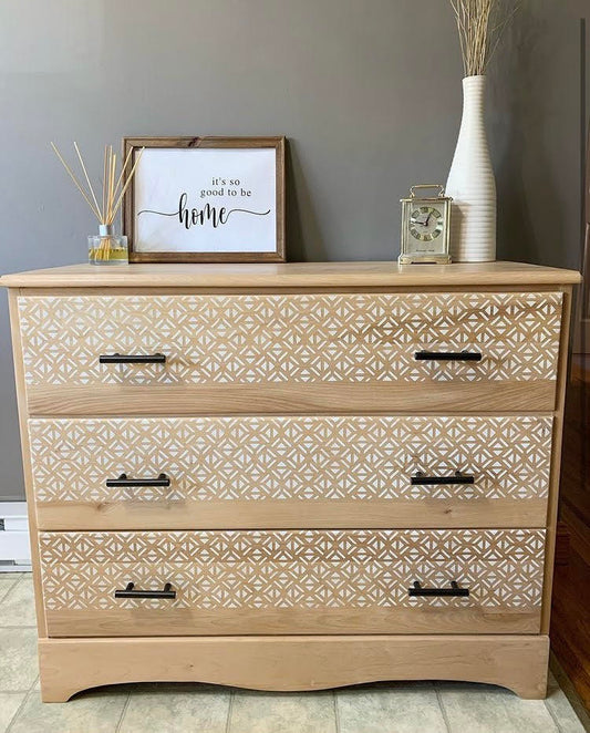 Natural wood dresser with white stenciled geometric pattern