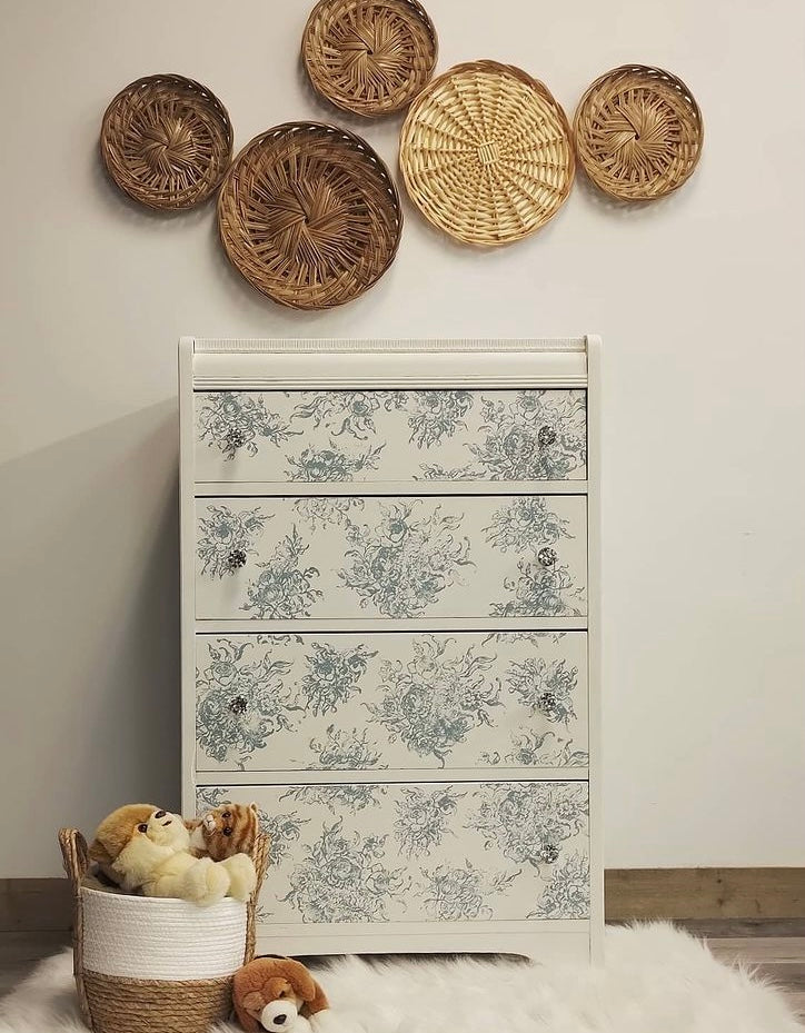 Antique inspired tallboy dresser painted white with floral stenciling and woven basket wall decor crystal knobs