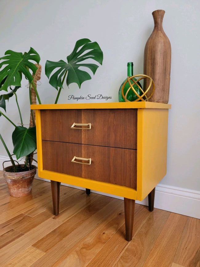 Mid century nightstand painted mustard yellow with raw wood drawers and legs