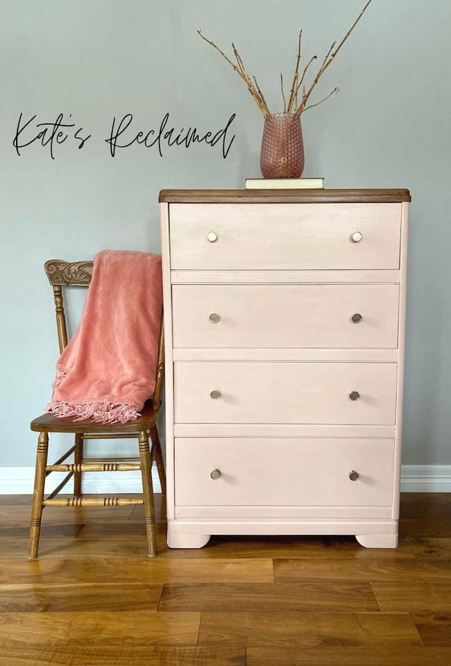 blush pink dresser with minimalist gold knobs and antique wooden pressback chair