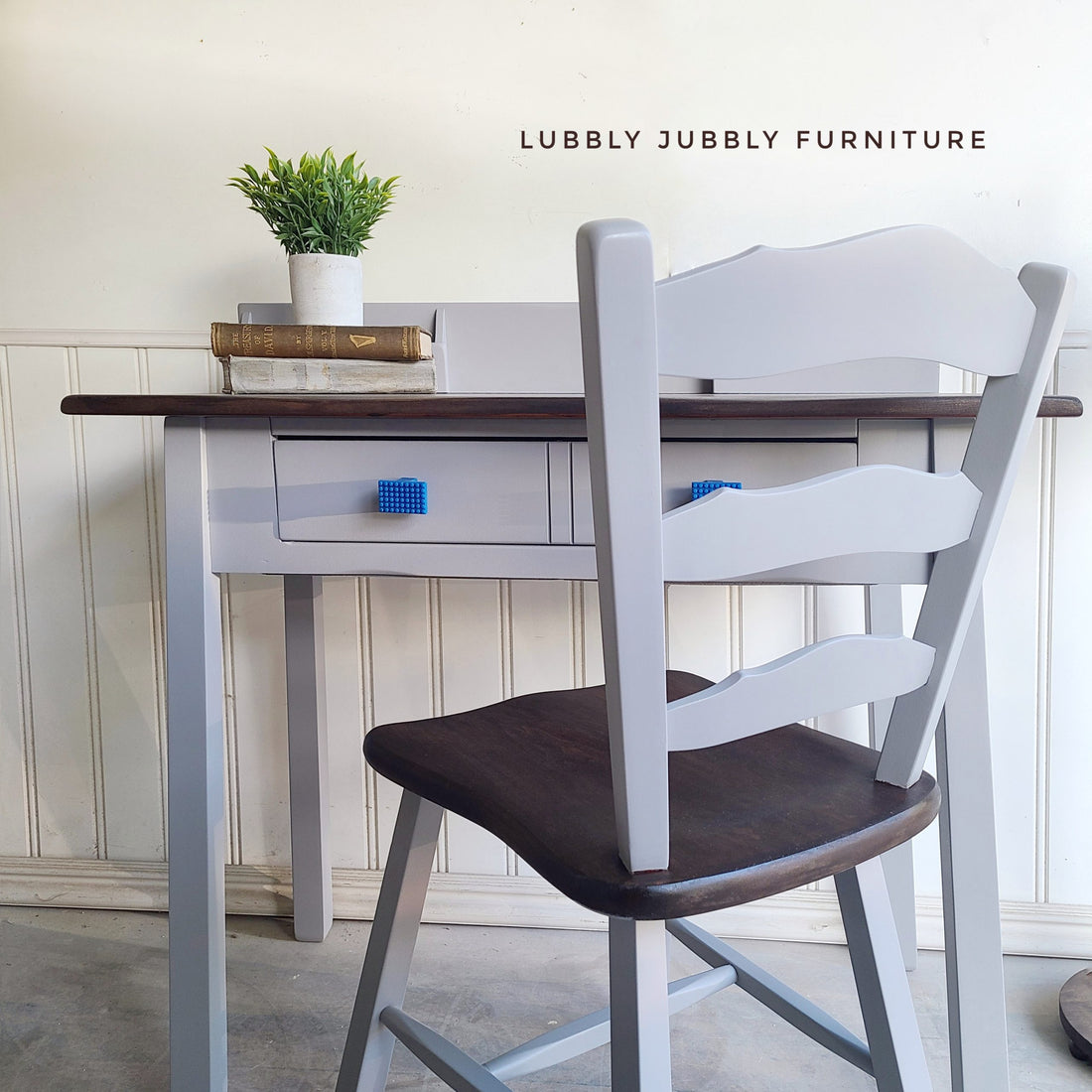 Matching grey painted desk and chair with stained wood top and blue rectangle knobs