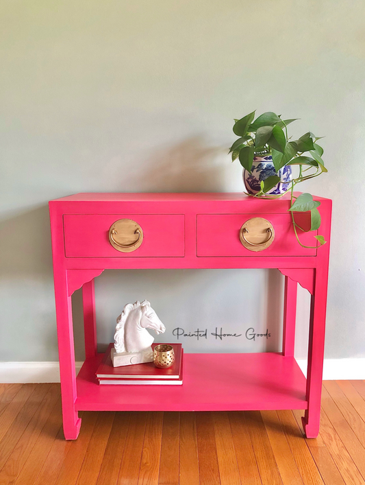 Accent table in deep ink with oversized gold hardware, bottom shelf, ceramic horse head, books, potted plant