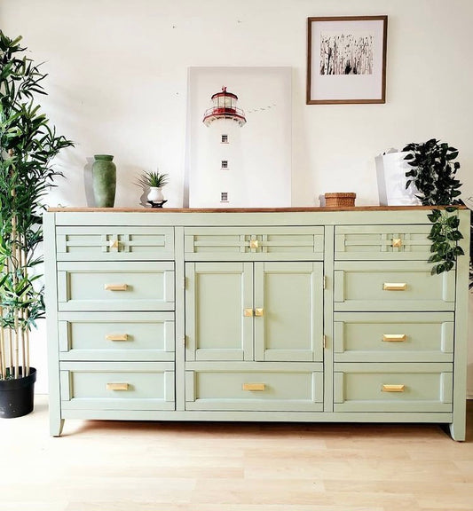 Sage green dresser with gold hardware square geometric pulls and lighthouse artwork