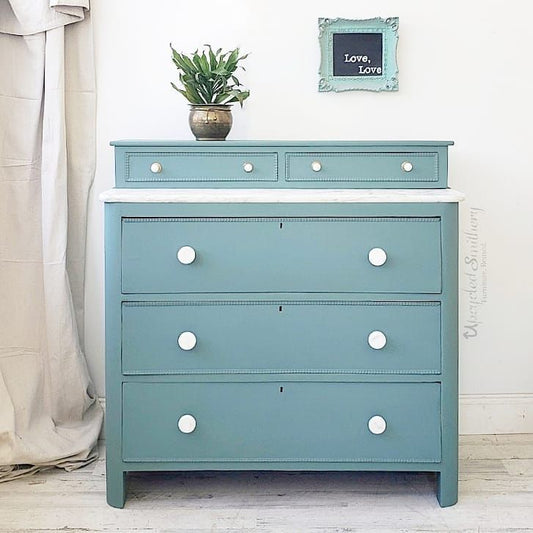 dresser in wanderess with marble top and porcelain knobs potted plant framed chalkboard