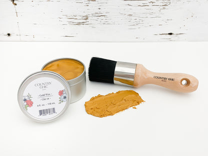 Flatlay of gold wax from country chic paint next to wax brush and smear of wax