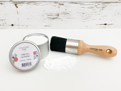 Flatlay of dark white wax from country chic paint next to wax brush and smear of wax